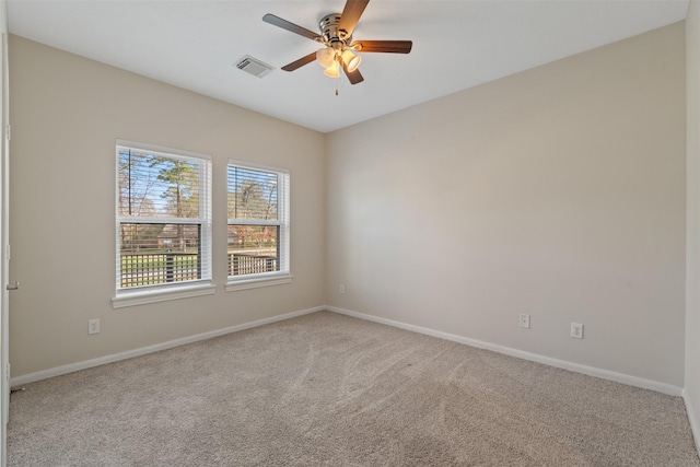 spare room with baseboards, visible vents, a ceiling fan, and light colored carpet