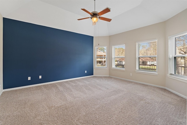 carpeted empty room with ceiling fan, vaulted ceiling, and baseboards