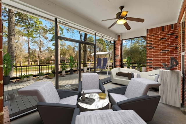 sunroom / solarium featuring a ceiling fan