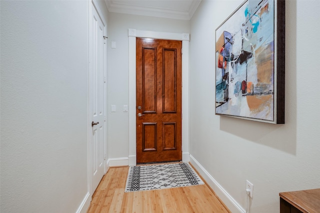 doorway with ornamental molding and light hardwood / wood-style floors