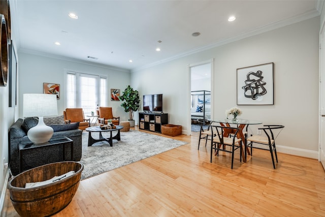 living room with light hardwood / wood-style flooring and ornamental molding