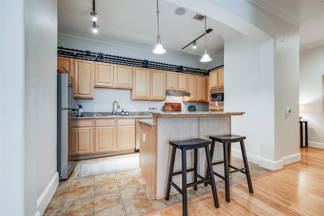 kitchen featuring pendant lighting, appliances with stainless steel finishes, ornamental molding, light stone countertops, and a kitchen island