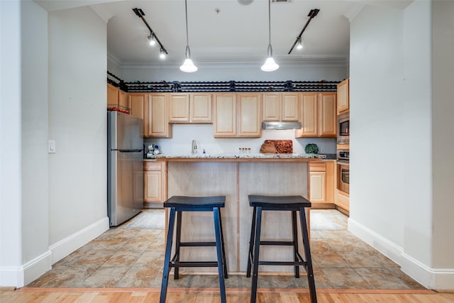 kitchen with a breakfast bar area, decorative light fixtures, light brown cabinets, a kitchen island, and stainless steel appliances