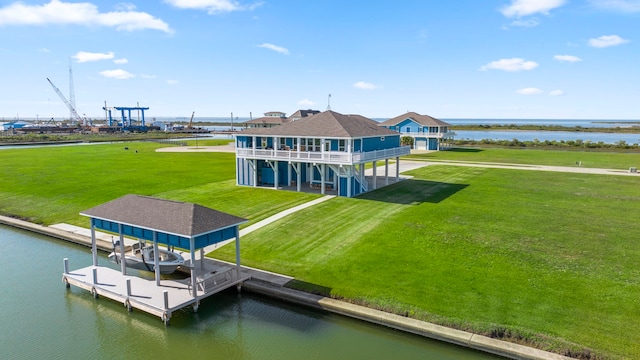 back of property featuring a water view and a lawn