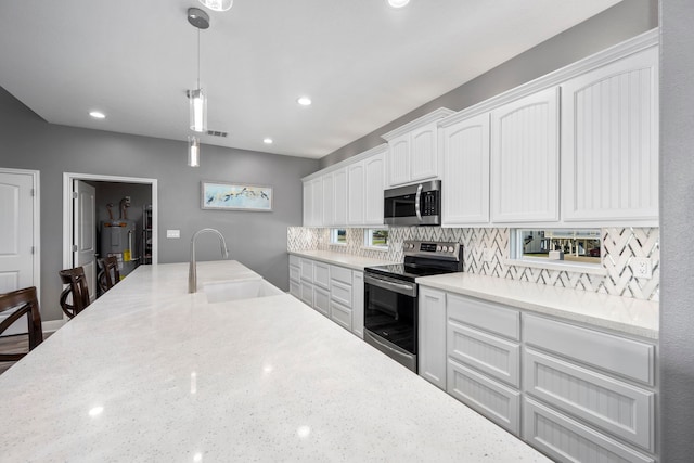 kitchen with pendant lighting, sink, stainless steel appliances, tasteful backsplash, and white cabinets