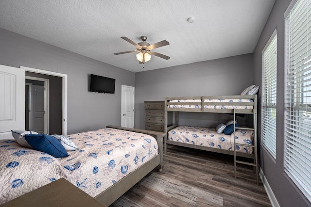 bedroom with dark wood-type flooring, ceiling fan, and a textured ceiling