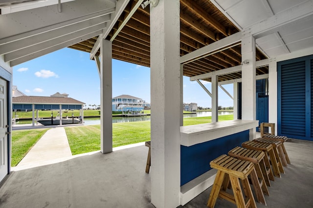 view of patio with a water view and exterior bar