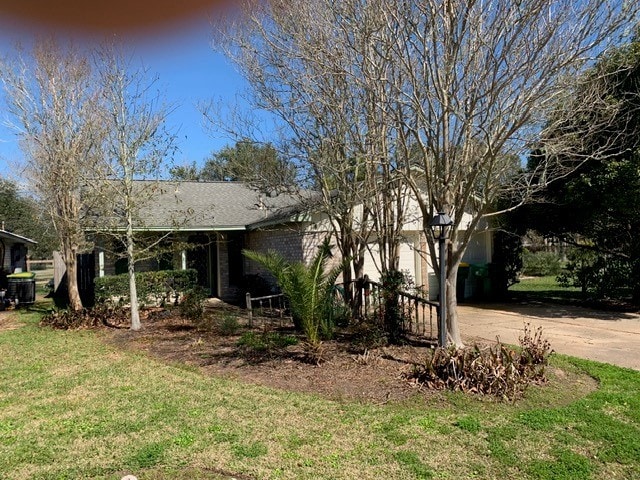 view of front of home featuring a garage, concrete driveway, and a front lawn