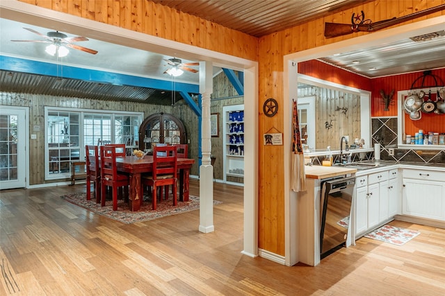 kitchen featuring sink, white cabinetry, light wood-type flooring, dishwasher, and decorative backsplash