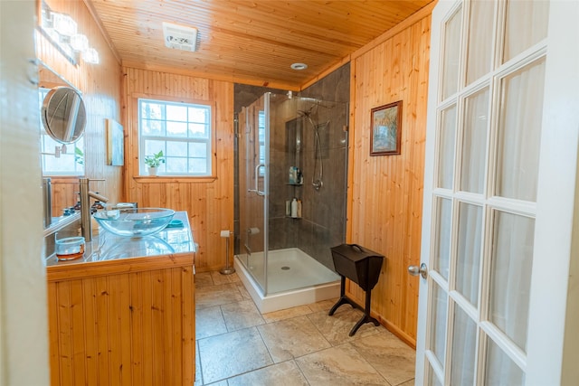 bathroom featuring wood ceiling, vanity, a shower with shower door, french doors, and wood walls