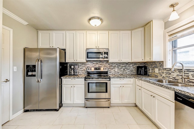 kitchen with appliances with stainless steel finishes, stone countertops, sink, and decorative backsplash