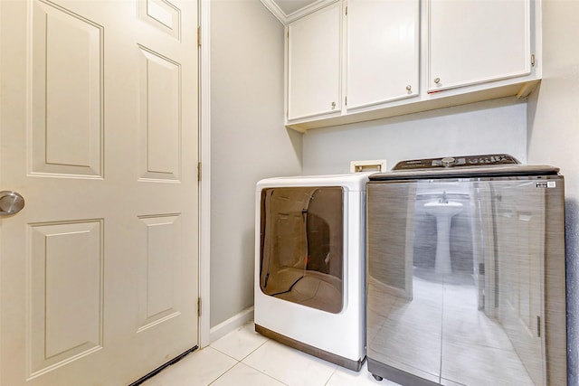 laundry room featuring cabinets, washing machine and dryer, and light tile patterned floors