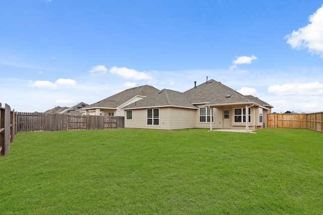 rear view of house with a lawn and a patio