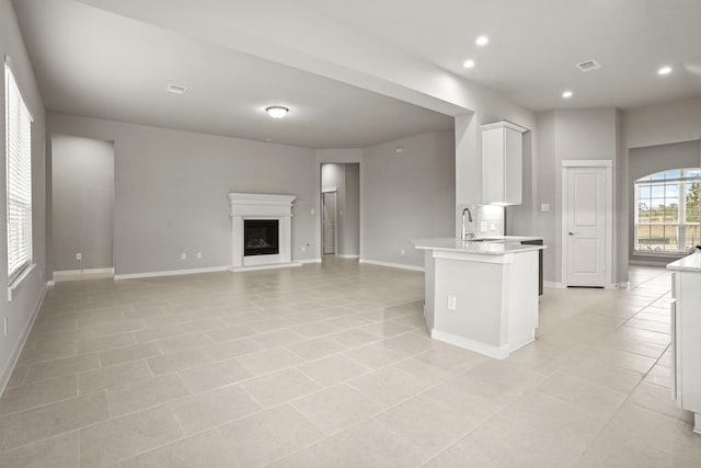 kitchen featuring white cabinetry, sink, and light tile patterned floors