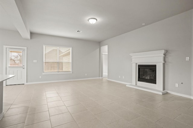 unfurnished living room with beamed ceiling and light tile patterned floors