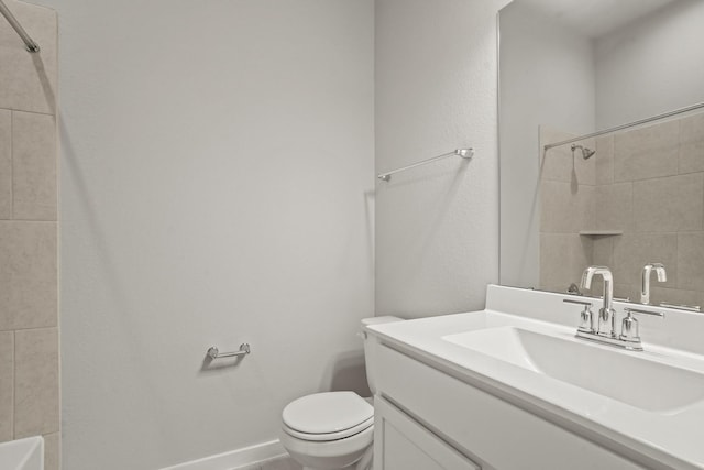 bathroom with vanity, tiled shower, and toilet