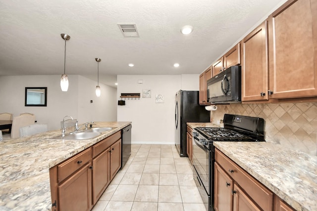 kitchen featuring sink, light stone counters, decorative light fixtures, decorative backsplash, and black appliances