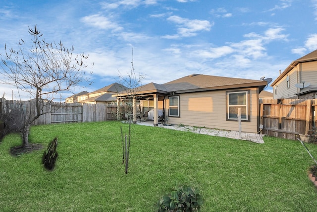 rear view of house with a yard and a patio