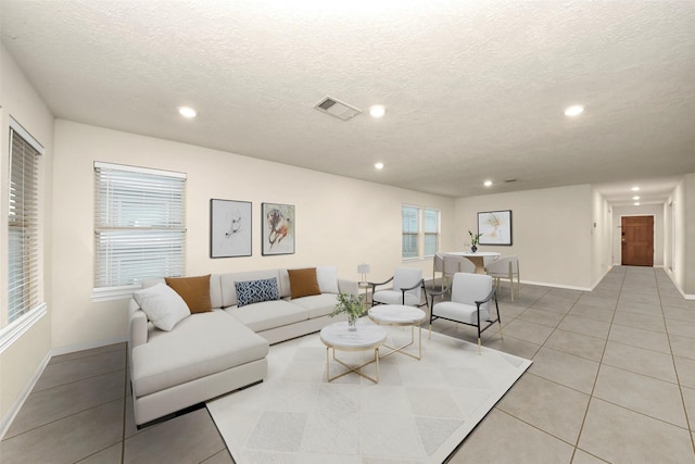 living room with light tile patterned floors and a textured ceiling