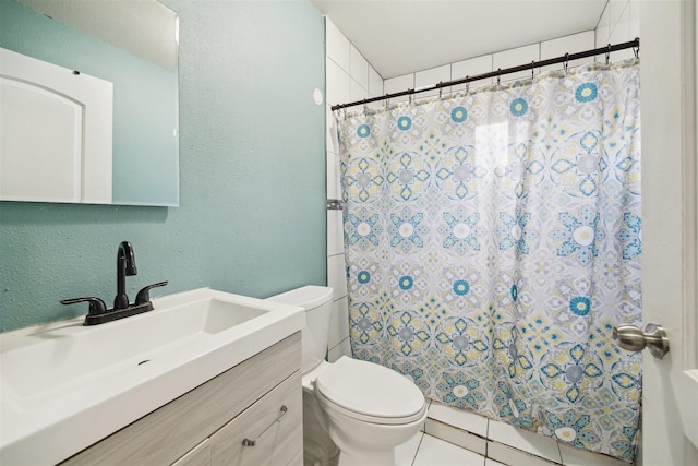 bathroom with tile patterned flooring, vanity, and toilet