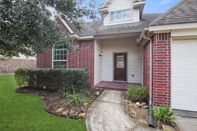 entrance to property featuring a garage and a lawn