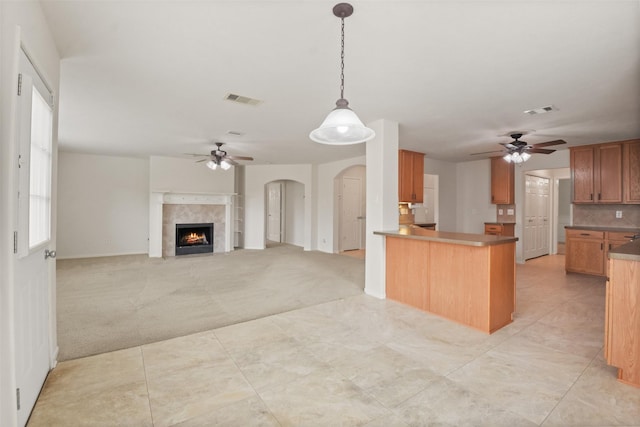 kitchen featuring hanging light fixtures, light carpet, ceiling fan, and kitchen peninsula