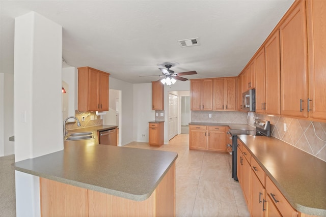 kitchen with tasteful backsplash, appliances with stainless steel finishes, sink, and kitchen peninsula