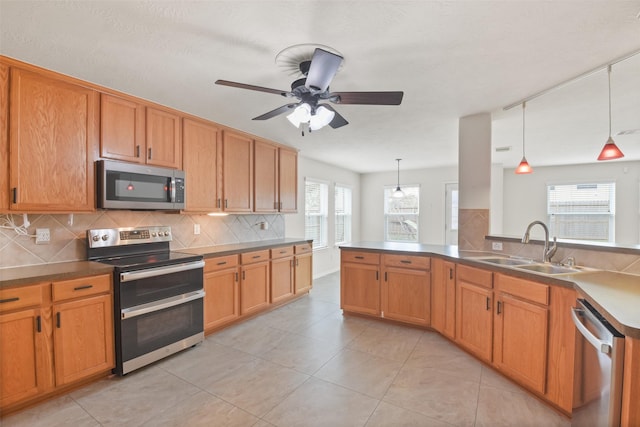 kitchen with sink, tasteful backsplash, hanging light fixtures, ceiling fan, and stainless steel appliances