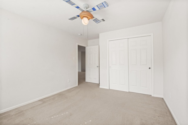 unfurnished bedroom with light colored carpet, a closet, and ceiling fan