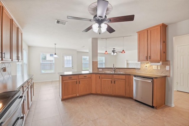 kitchen with appliances with stainless steel finishes, pendant lighting, sink, decorative backsplash, and kitchen peninsula