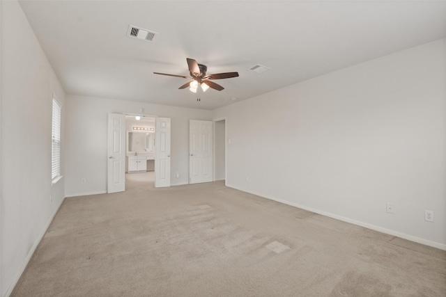 carpeted spare room with ceiling fan