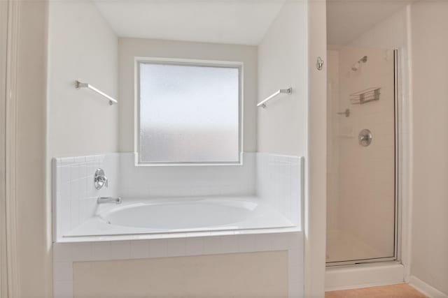 bathroom with a wealth of natural light and separate shower and tub