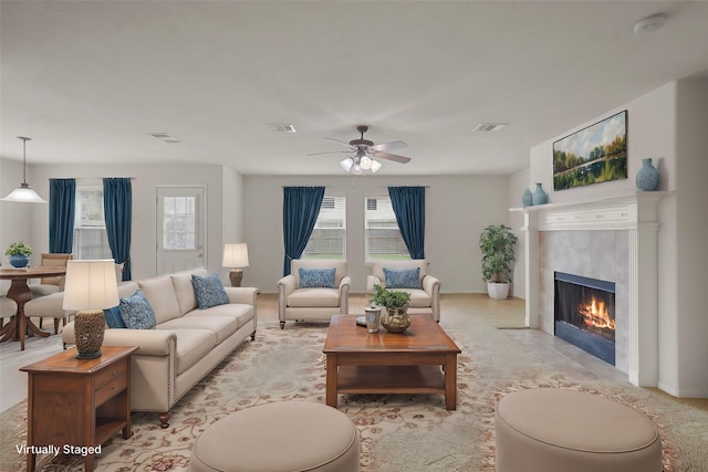 living room with ceiling fan and a tiled fireplace