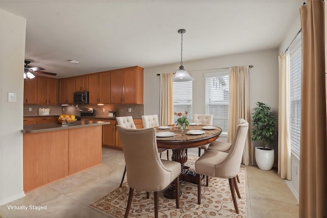 dining area with light tile patterned floors and ceiling fan