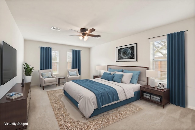 carpeted bedroom with multiple windows and ceiling fan