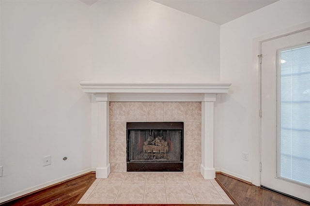 room details featuring a tiled fireplace and wood-type flooring