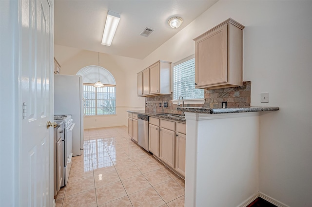 kitchen featuring sink, dark stone countertops, backsplash, white range oven, and stainless steel dishwasher