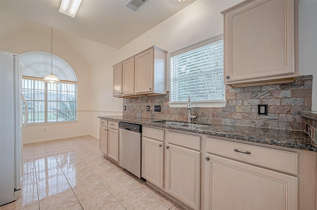 kitchen featuring sink, dishwasher, white refrigerator, decorative light fixtures, and cream cabinetry