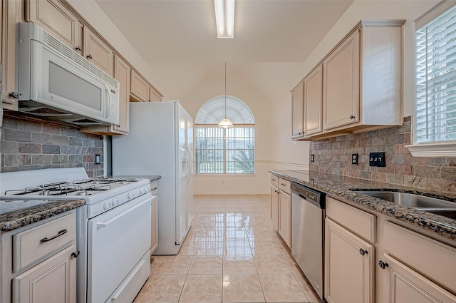 kitchen with light tile patterned flooring, white appliances, stone countertops, and decorative light fixtures