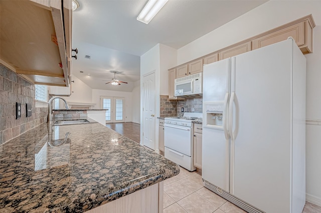 kitchen with light brown cabinets, sink, dark stone countertops, and white appliances