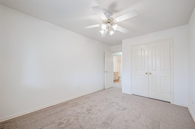 unfurnished bedroom featuring light carpet, ceiling fan, and a closet