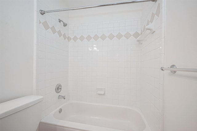 bathroom featuring tiled shower / bath and toilet