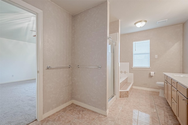 bathroom featuring tile patterned flooring, toilet, and walk in shower