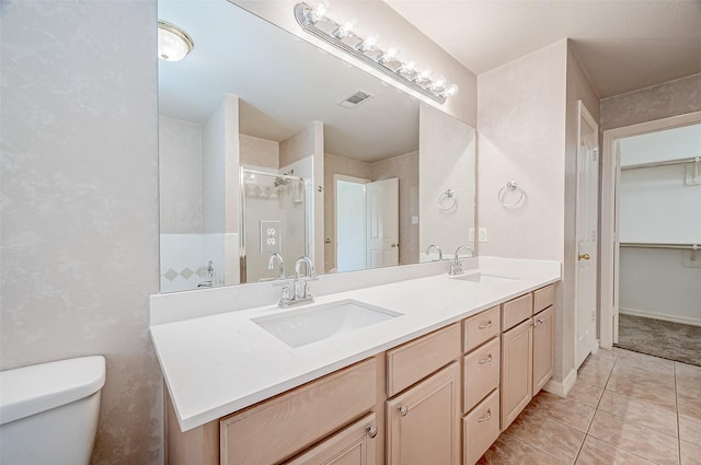 bathroom featuring walk in shower, tile patterned floors, vanity, and toilet