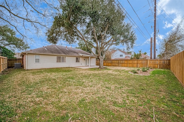 back of property with central AC, a patio, and a lawn