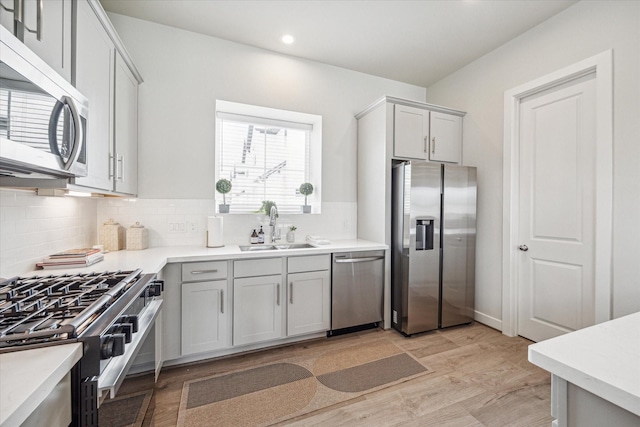 kitchen with sink, backsplash, and appliances with stainless steel finishes