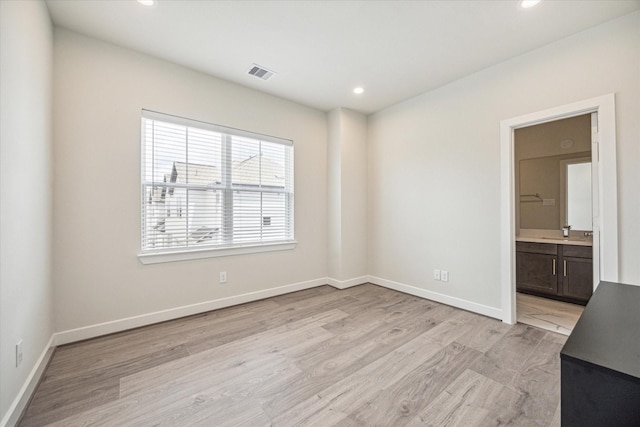 empty room with sink and light wood-type flooring