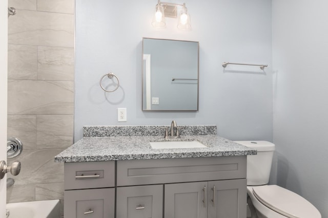 full bathroom featuring tiled shower / bath combo, vanity, and toilet