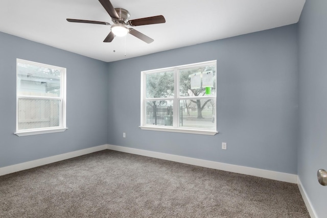 carpeted empty room with ceiling fan and plenty of natural light