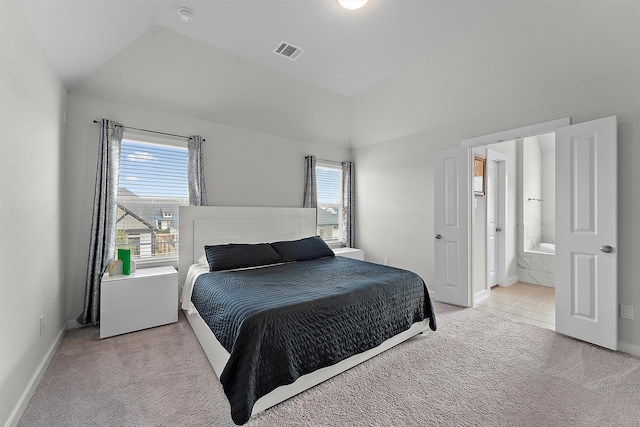 carpeted bedroom with lofted ceiling and ensuite bath